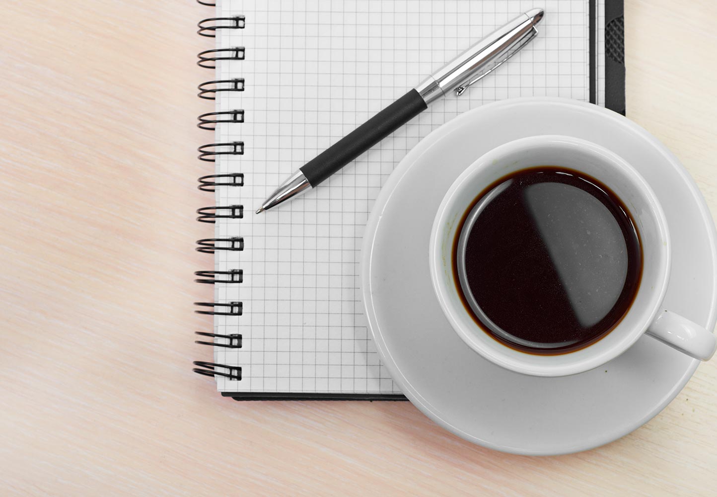 A coffee cup and a pen and paper